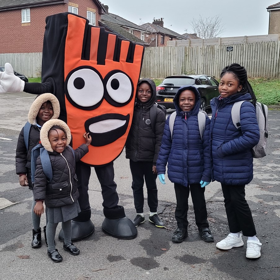 A groups of five pupils with Strider, Living Streets' mascot