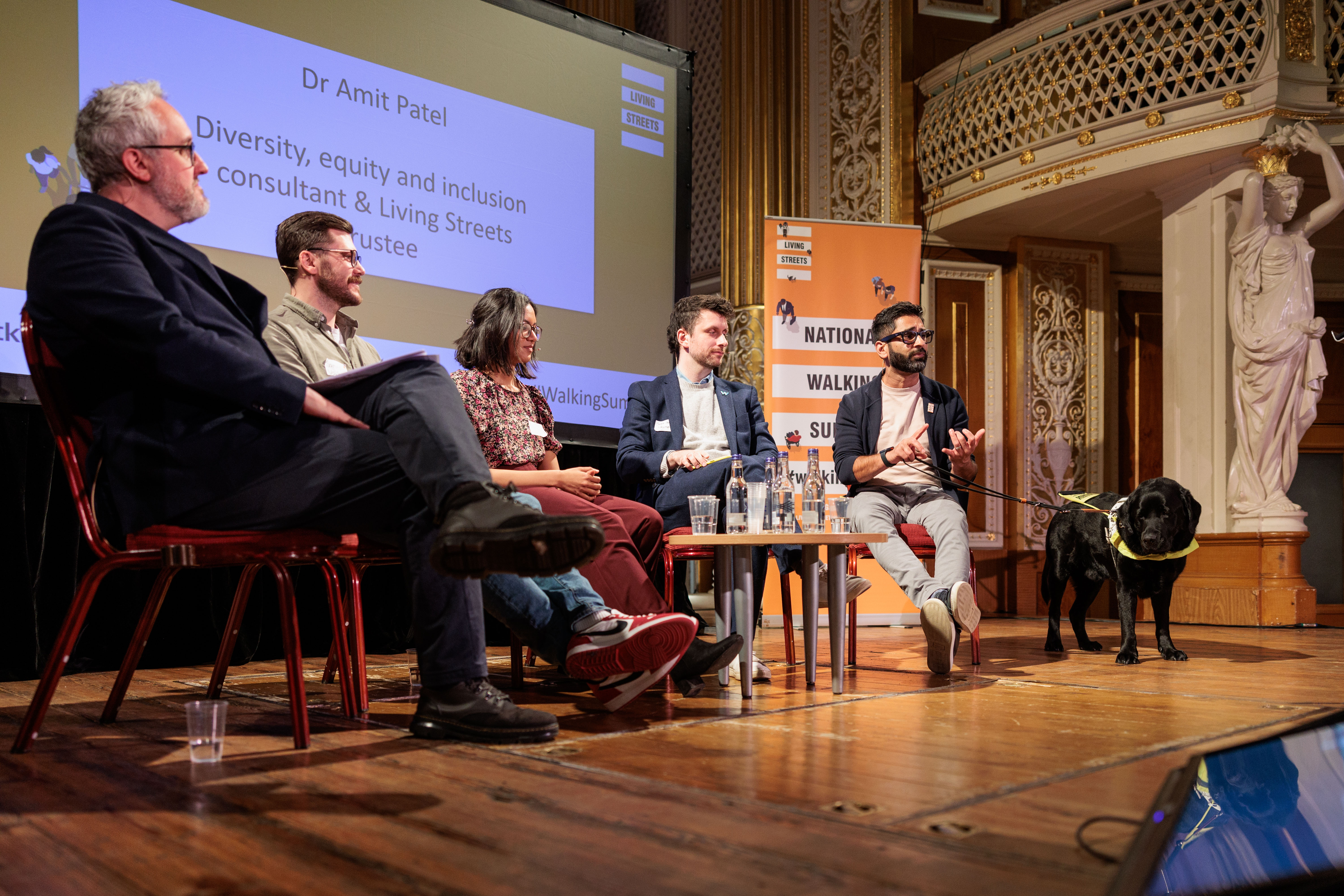 Five people sit on a panel discussing walking and wheeling