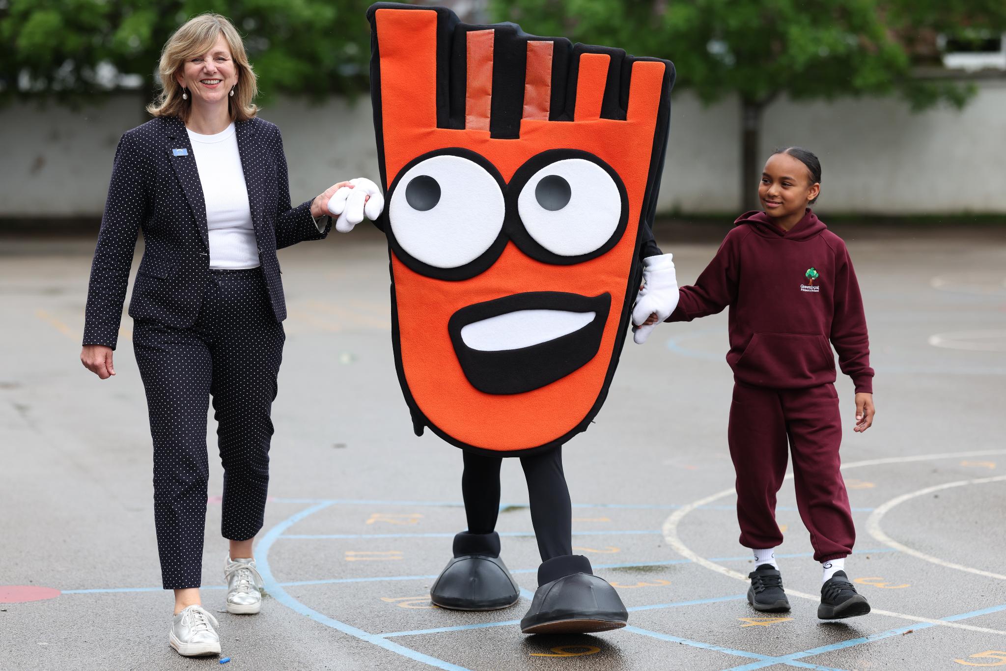 Lilian Greenwood and a pupil with Living Streets' mascot, Strider