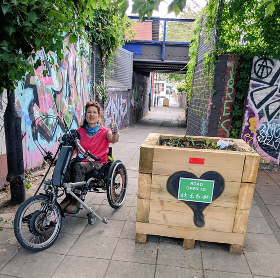 woman in a wheelchair bicycle gives the thumbs up for pedestrian only pathway