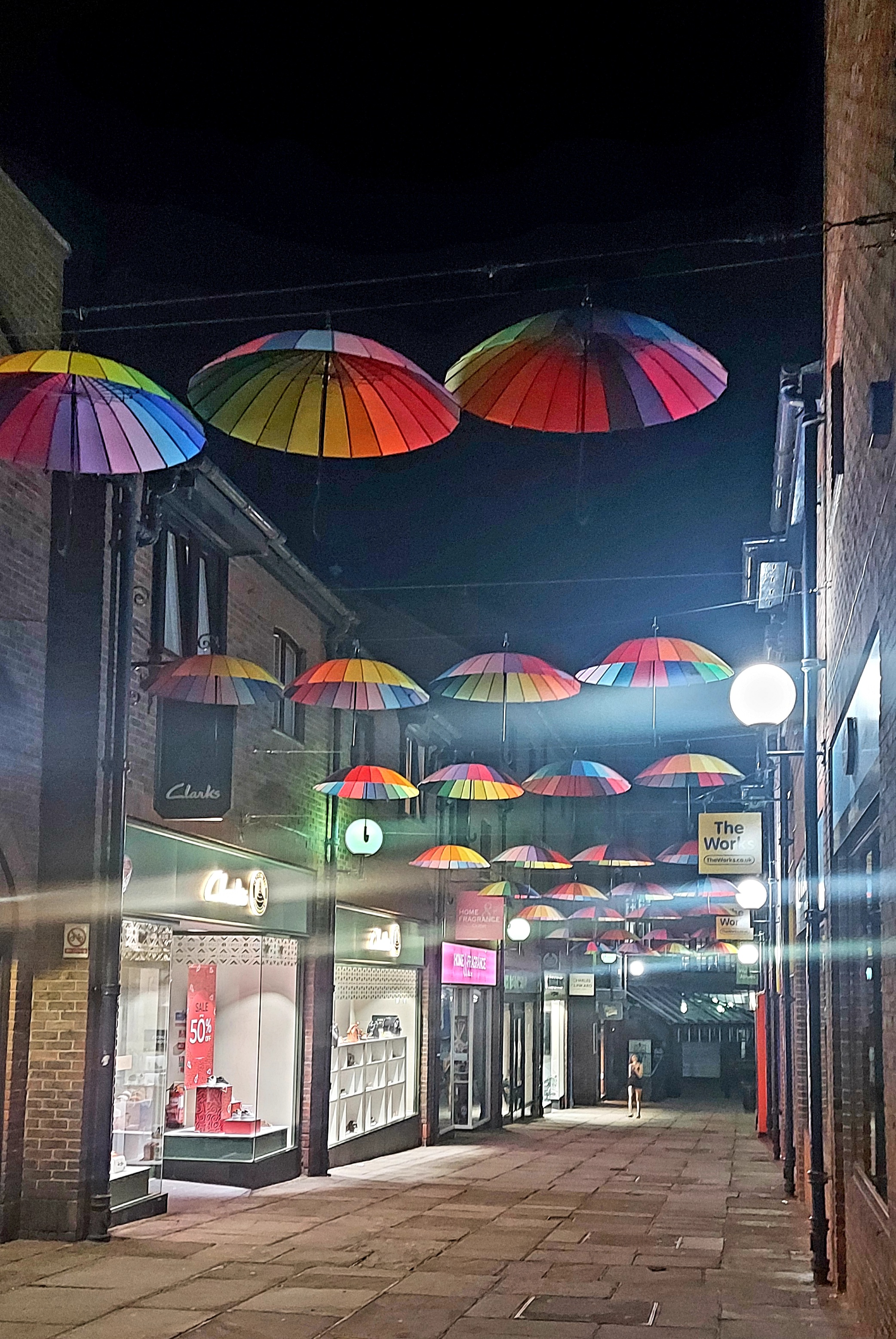 rainbow umbrellas line a street skyline