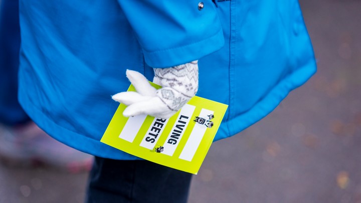 picture of a woman with gloved on holding a living streets leaflet