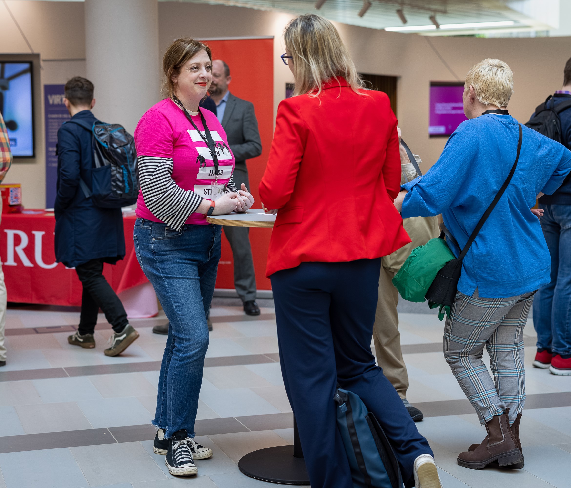 a woman in a pink Living Streets tshirt talks to a member of the public