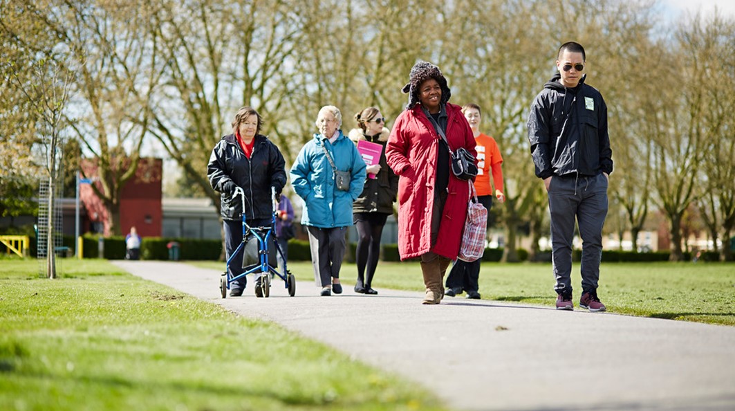 a group of people walk through the park