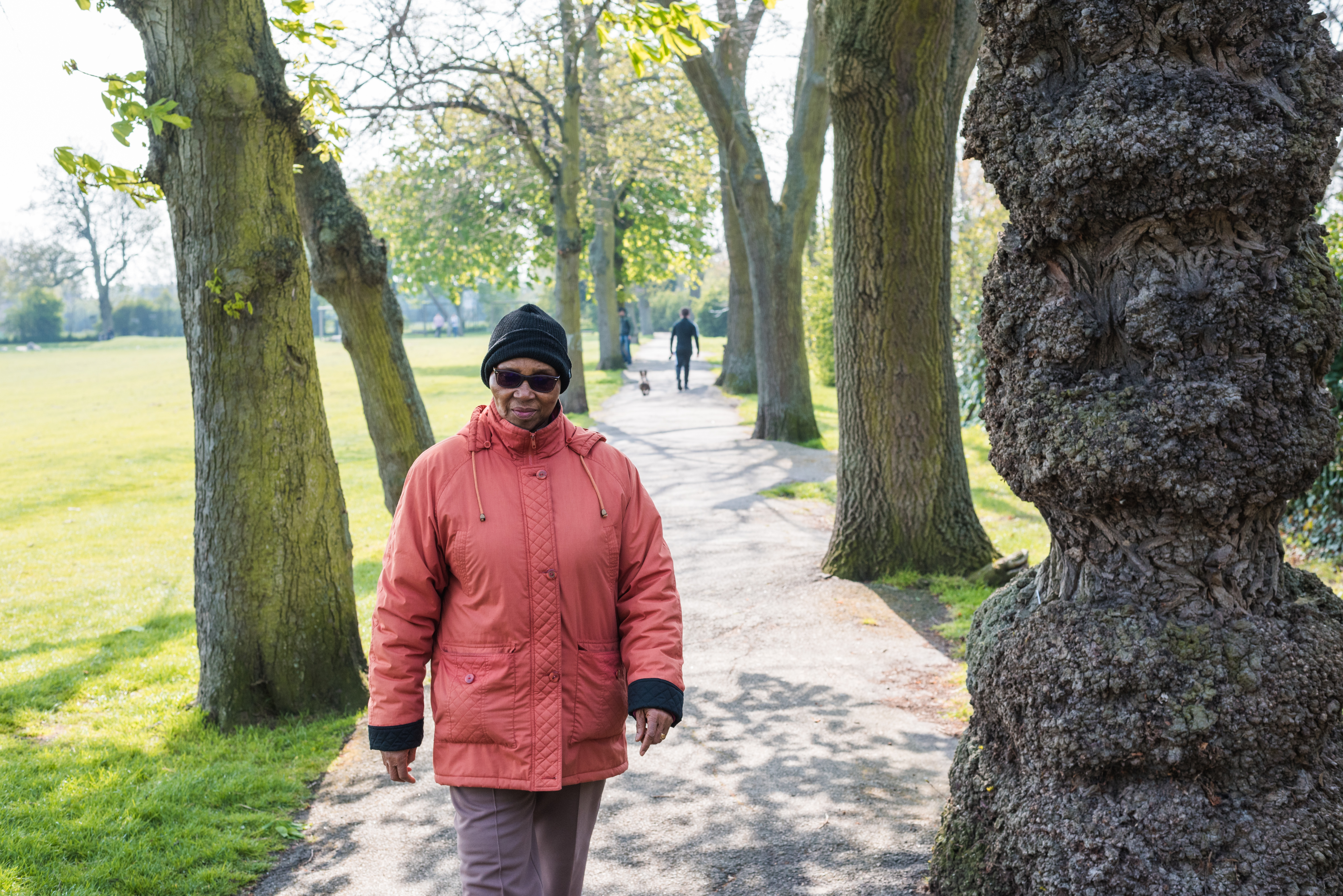 A woman walking down a footpath in a public space