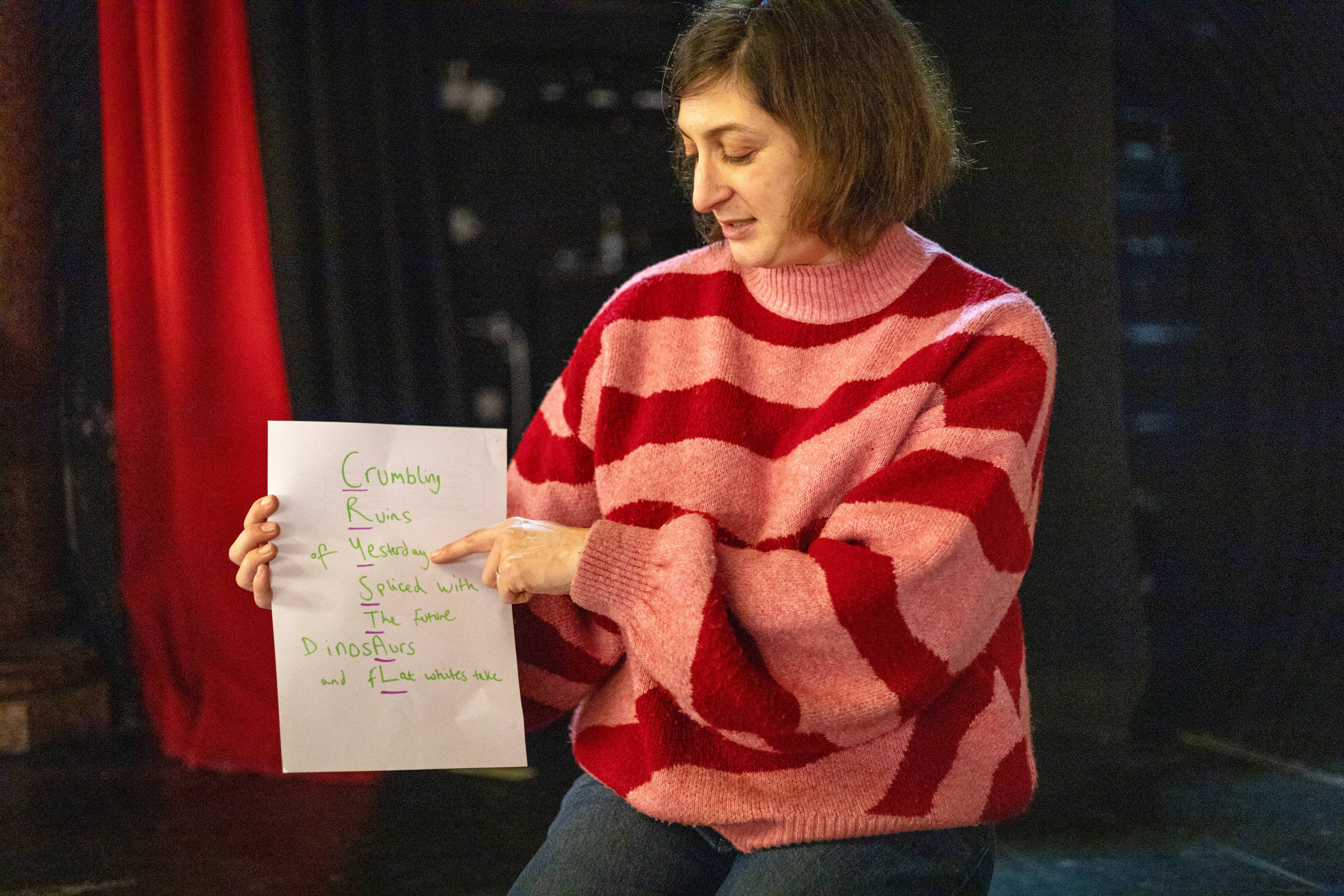 Sharon is holding up a piece of paper and is talking about it