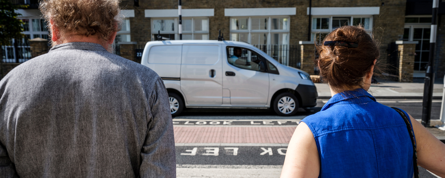 two people waiting at a zebra crossing