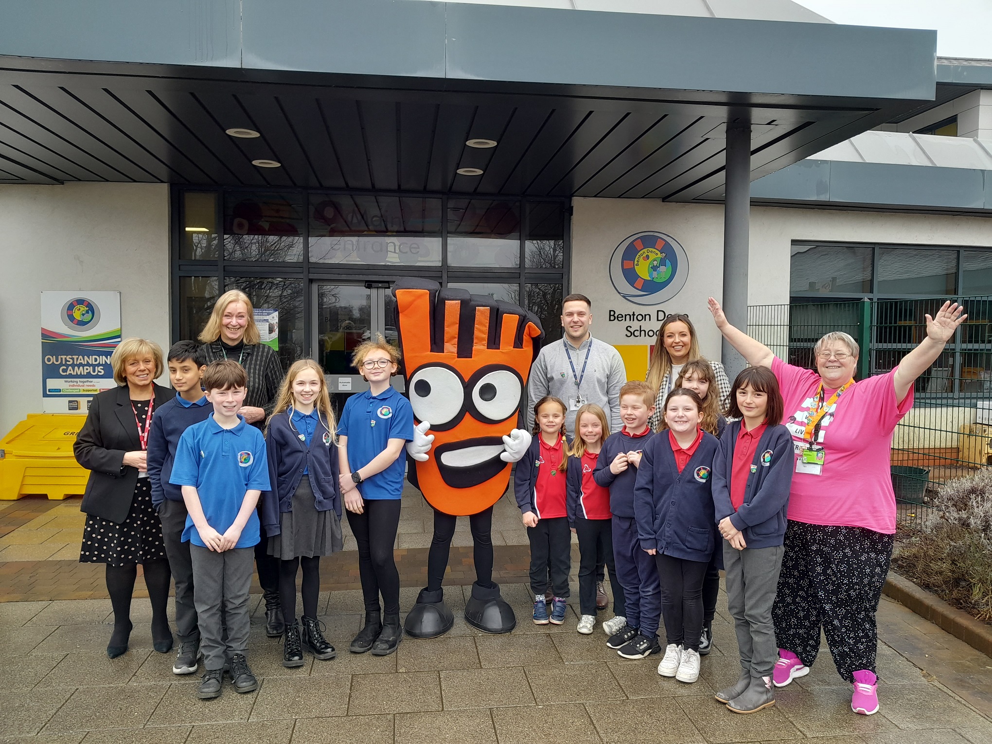 Mary Glindon MP and Cllr Janet Hunter are stood with Strider - Living Streets' mascot - and pupils and staff from Benton Dene Primary school.