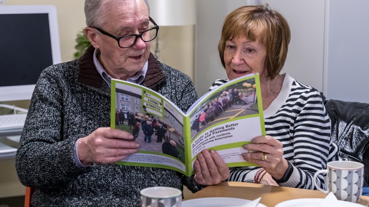 two older people reading Living Streets leaflet