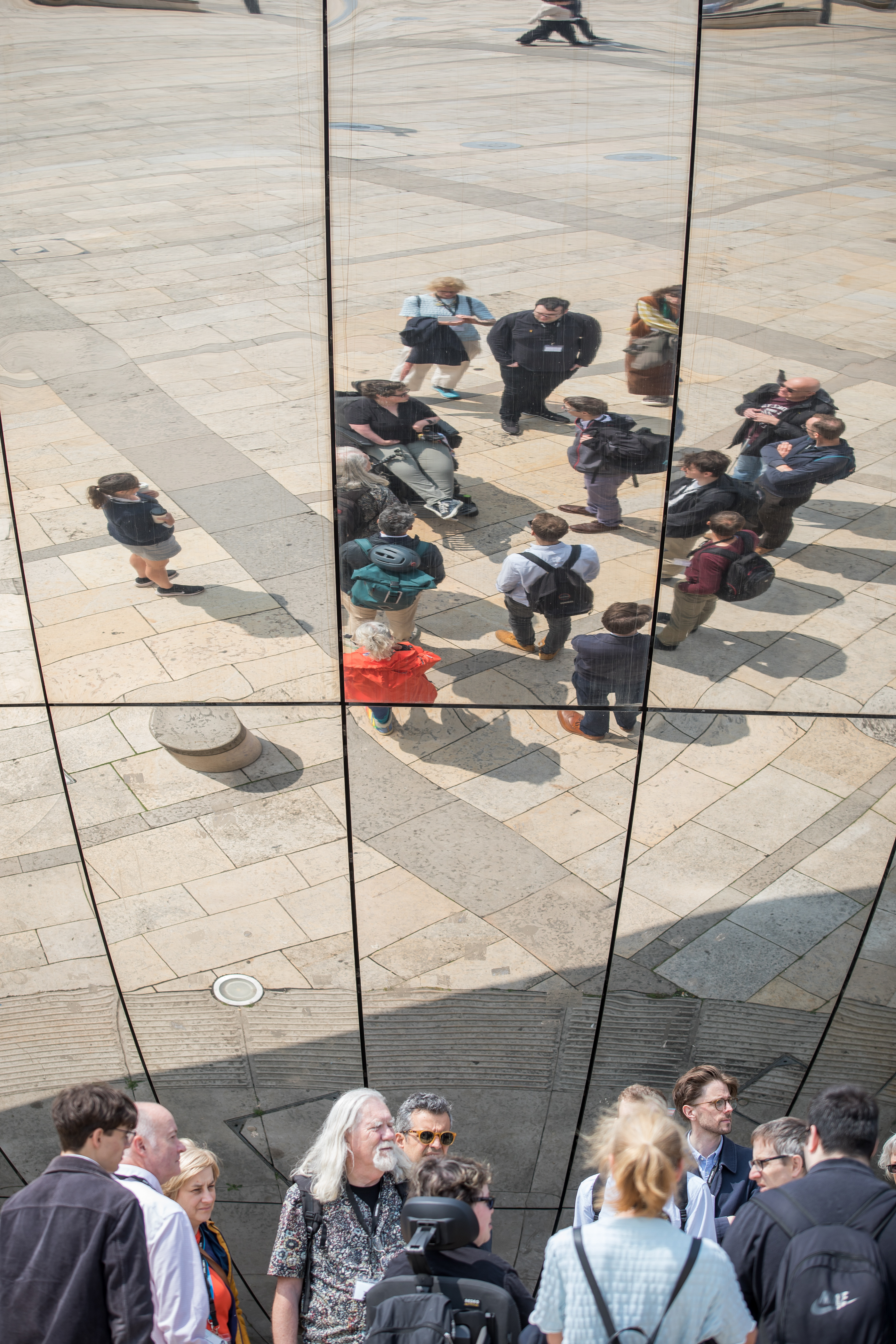 Walkshop attendees are gathered in Bristol City Centre close to a reflective obelisk