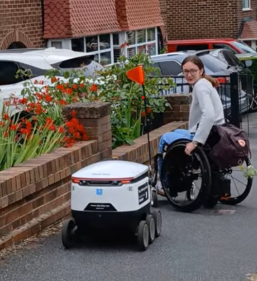 Emily, in her wheelchair, interacts with a robot in Leeds