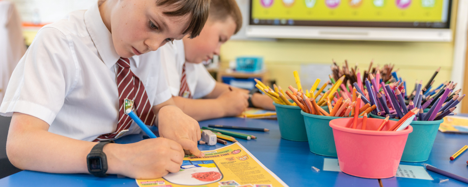 a young boy drawing at school