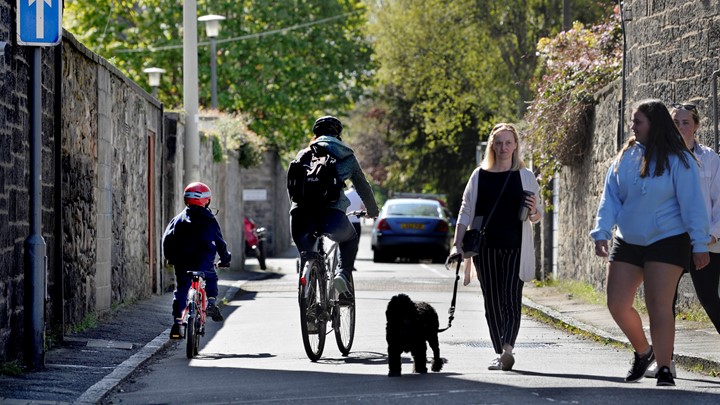 a group of people walk down a street