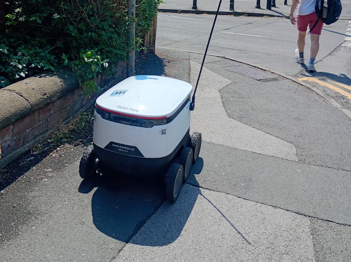 A photo of a delivery robot on a pavement in Leeds