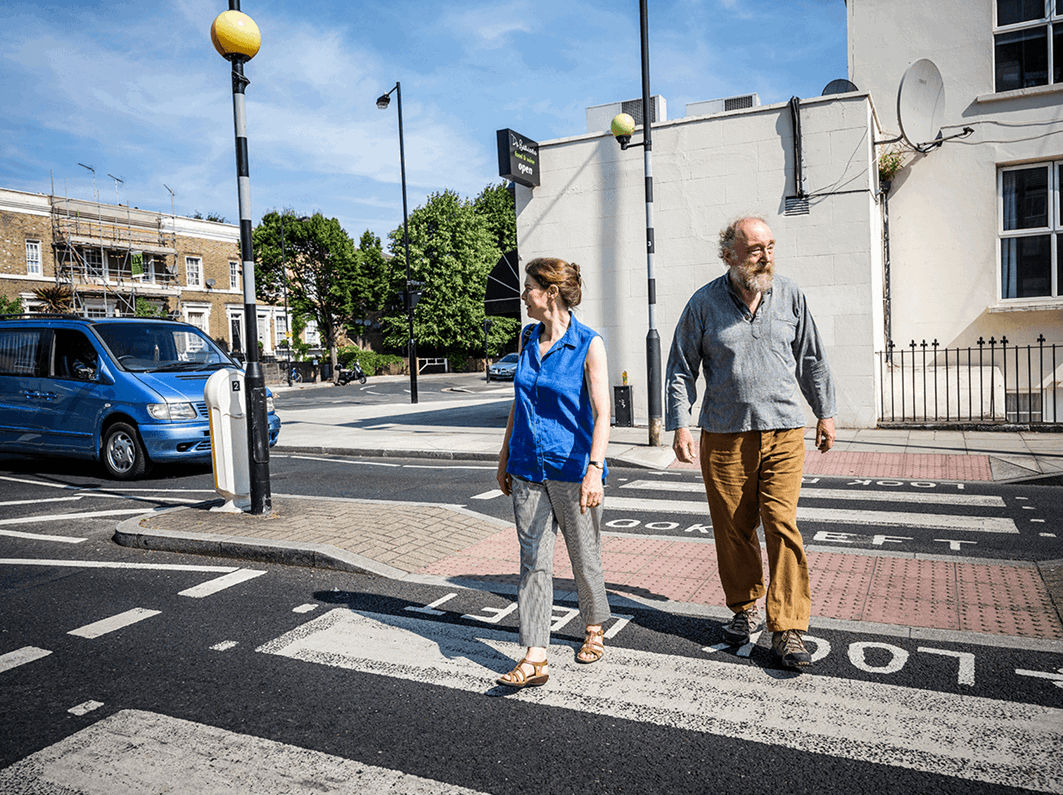 A man and a woman waling on a zebra crossing