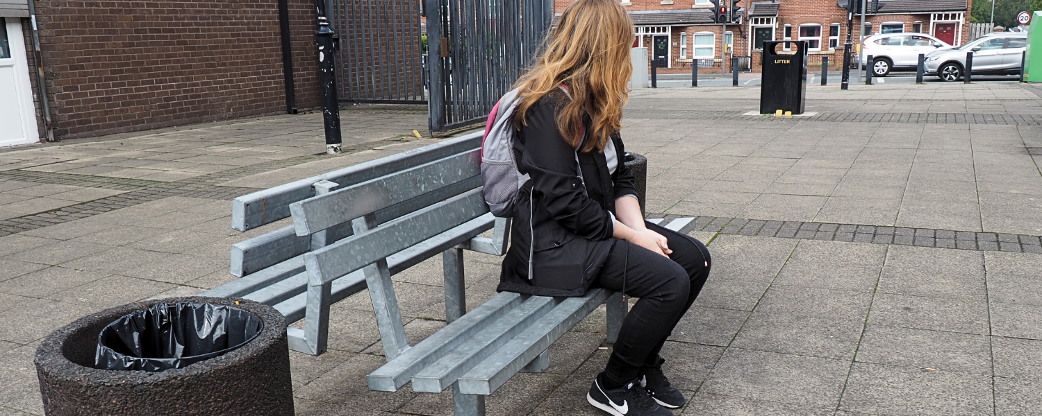 a woman sits on a park bench