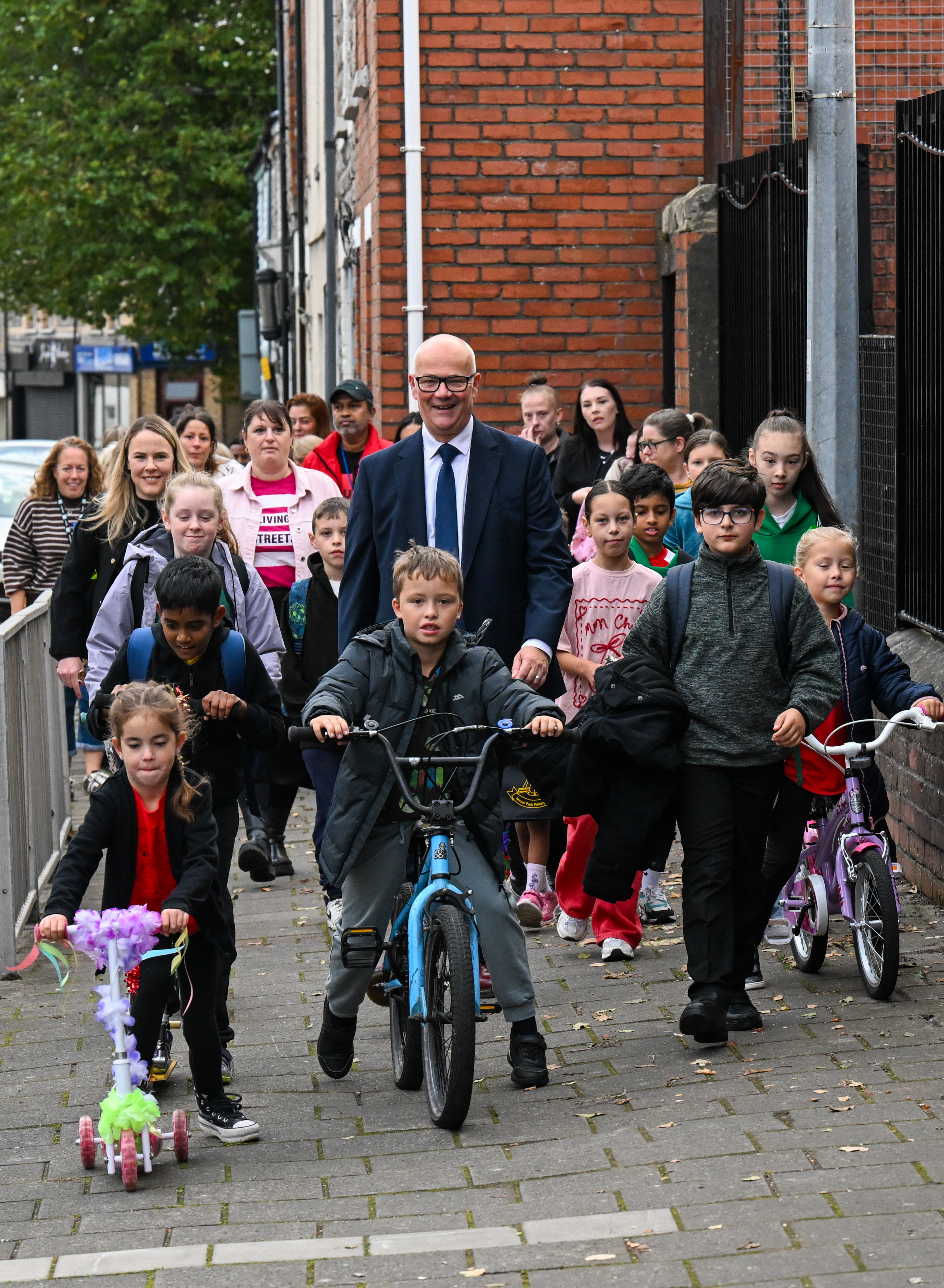 Deputy Minister for Tranport Mark Hooper MS walking with pupils from Ysgol Gynradd Parc Jenner Park Primary School and Living Streets