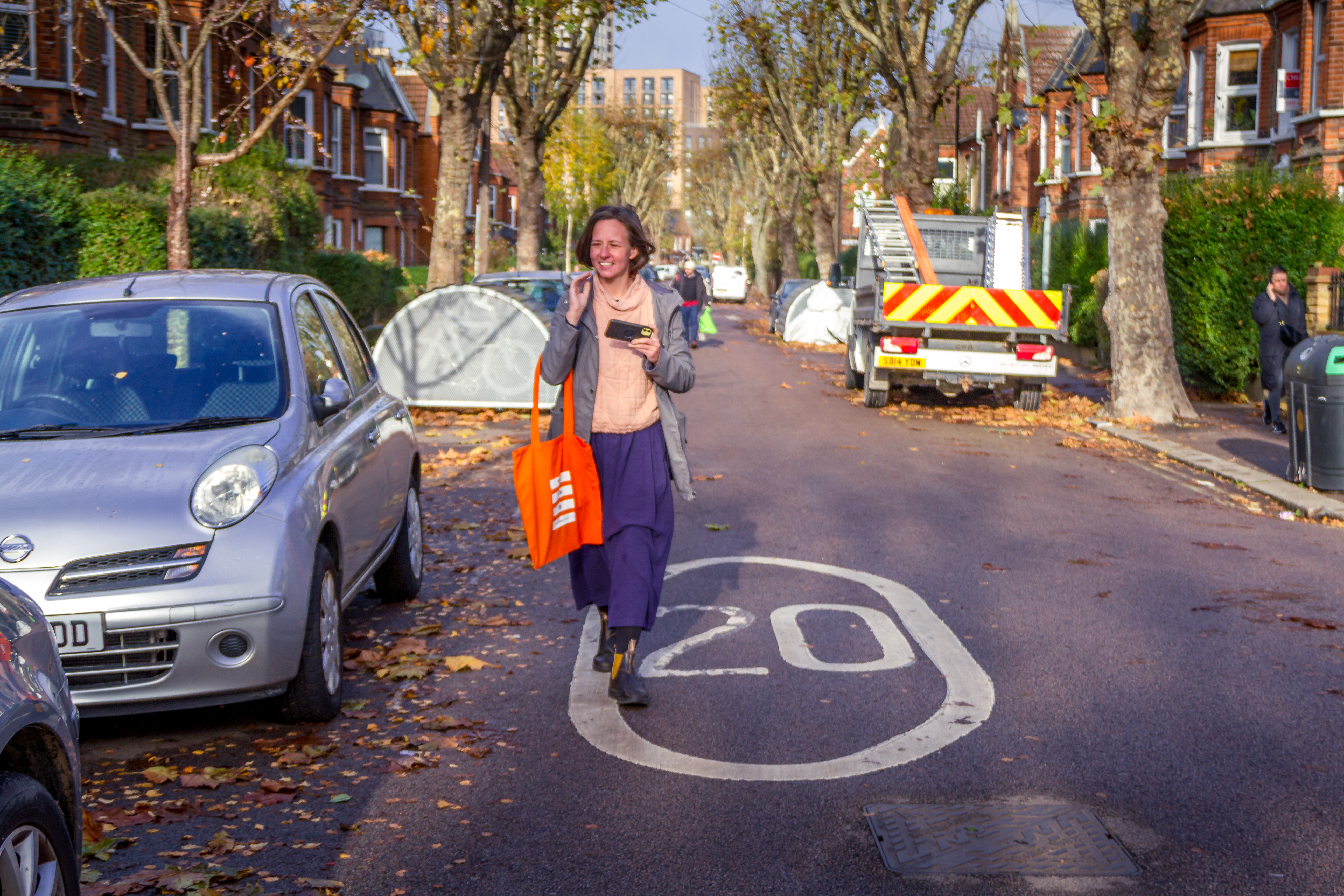 woman walks past a 20mph road sign