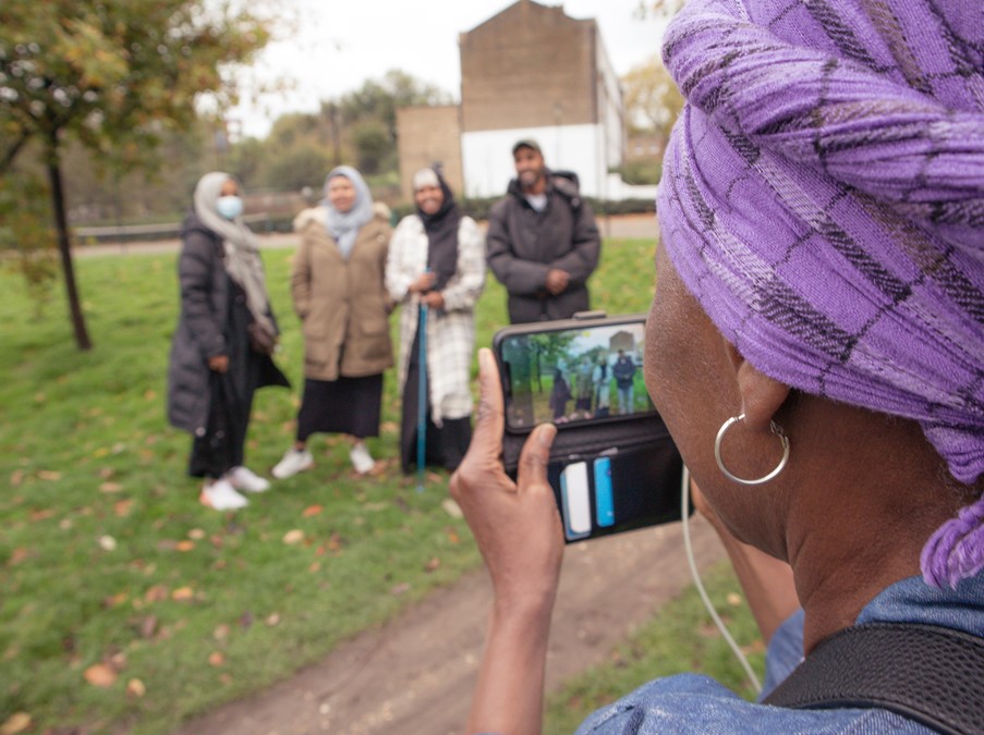 A woman taking a photo of four other people