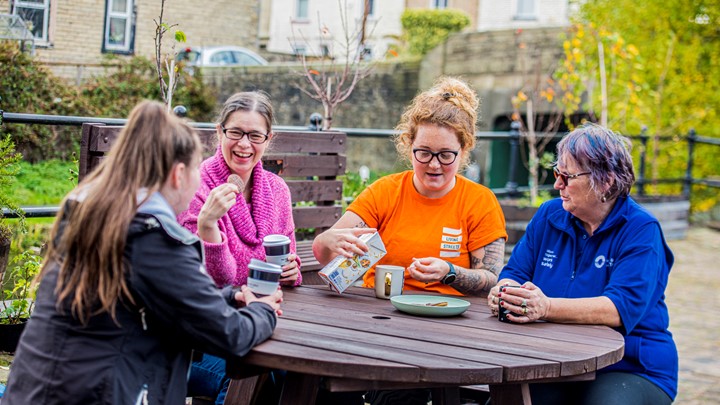 a group of people sit round a table having a tea