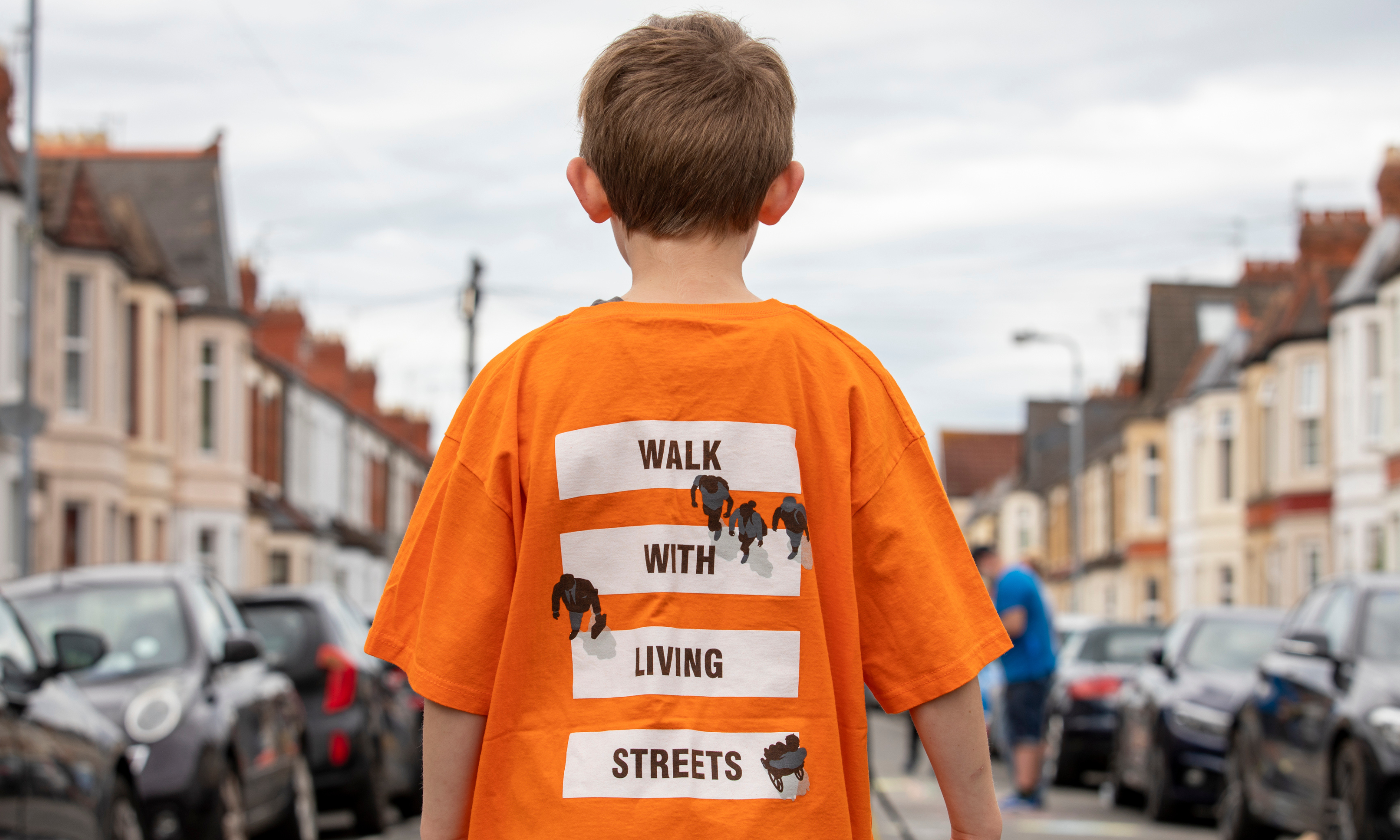 little boy wearing orange walk with living streets tshirt