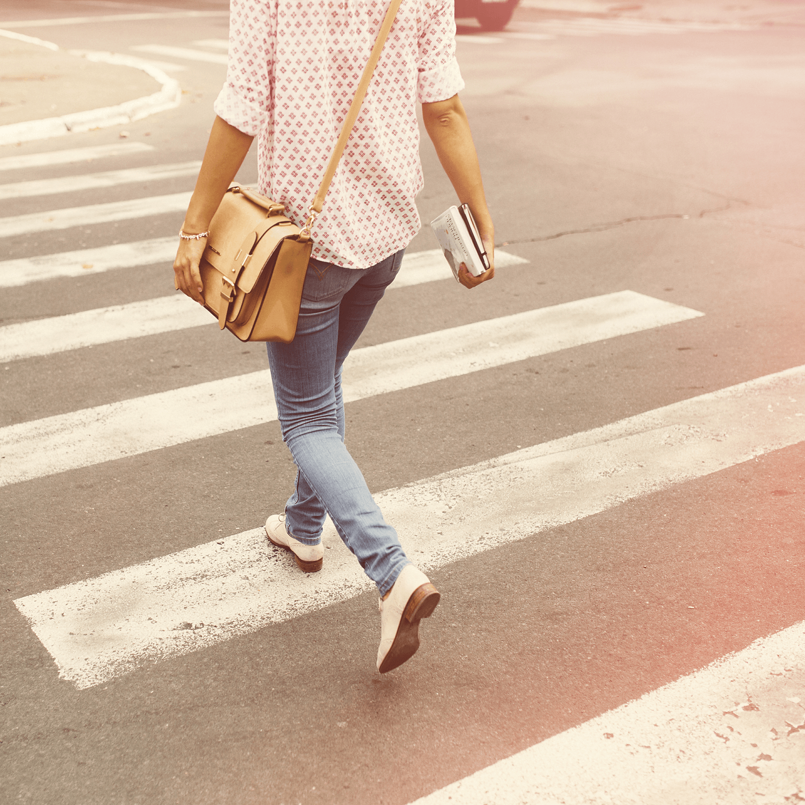 a woman walks across a zebra crossing