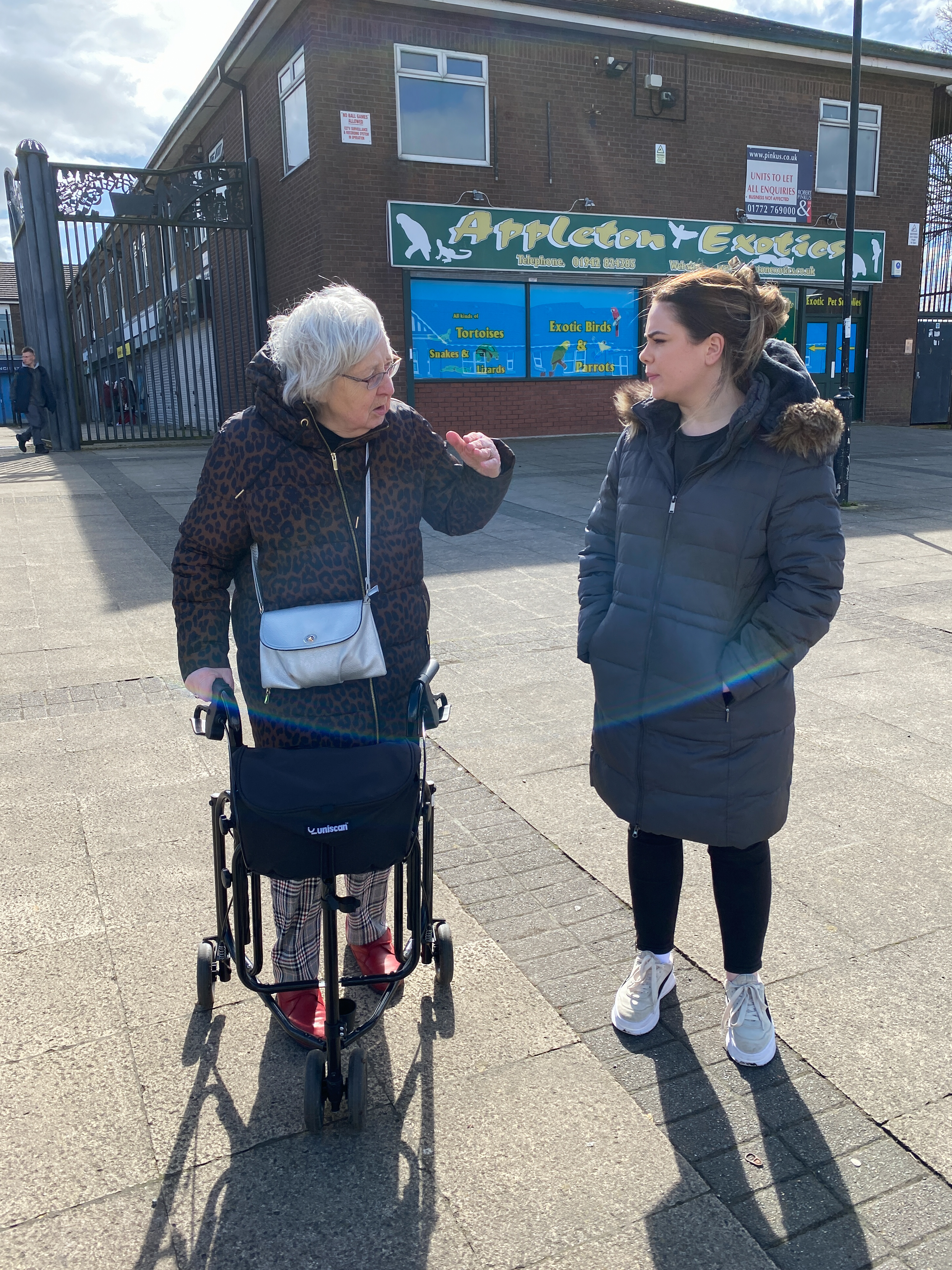 Two women, one is using a walker