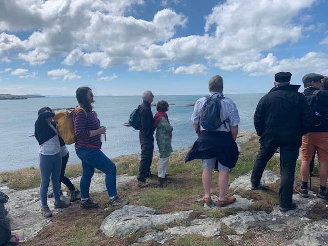 A group of people on a walk by Trearddur Bay